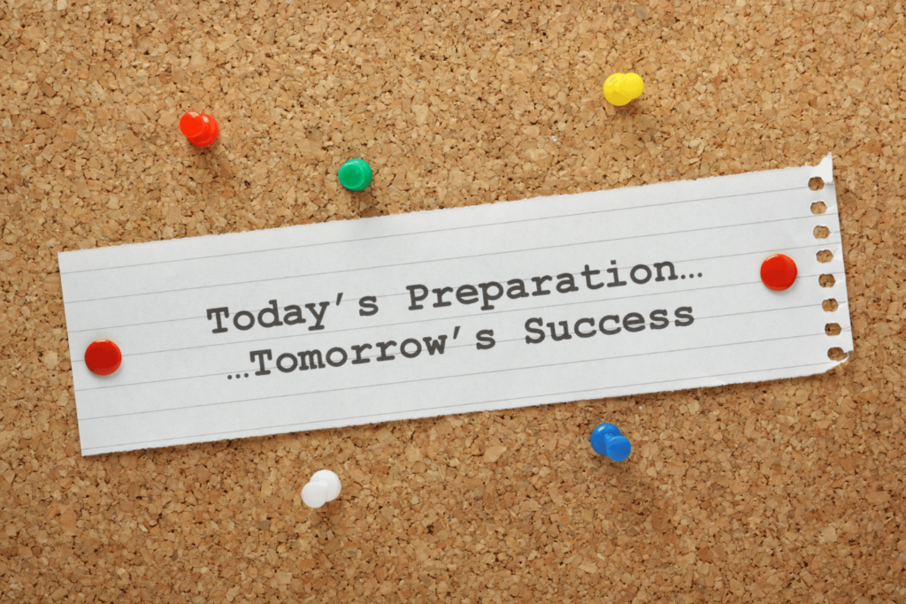 A note on a bulletin board with colorful tacks reads, Today’s preparation…tomorrow’s success.