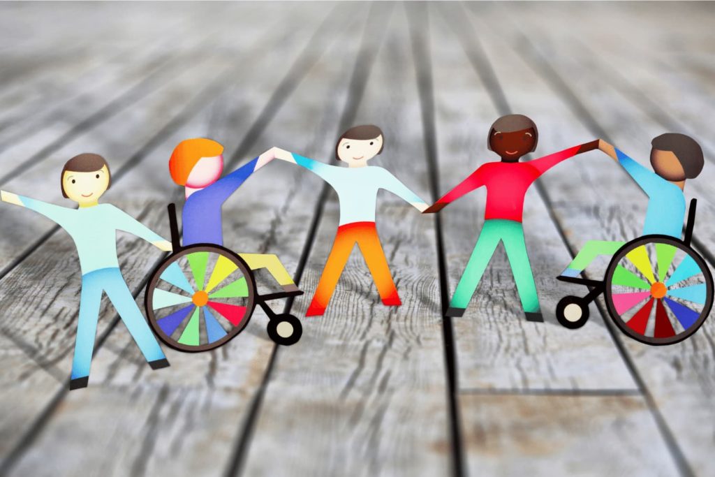 Paper cutouts of five racially diverse people holding hands, two using wheelchairs.