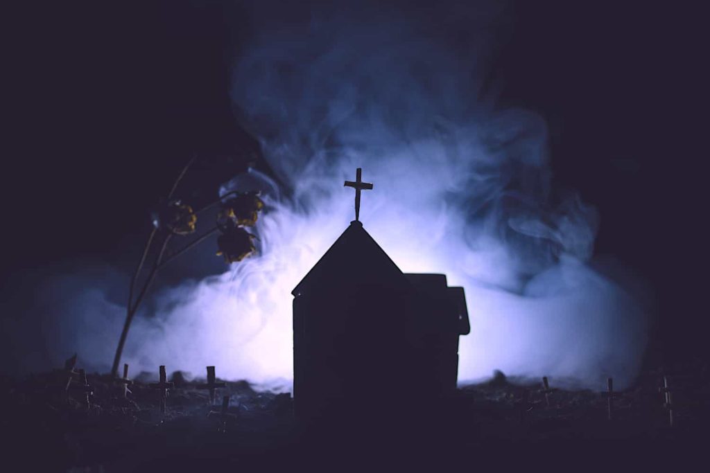 A photo of silhouette of prairie church on a misty night.