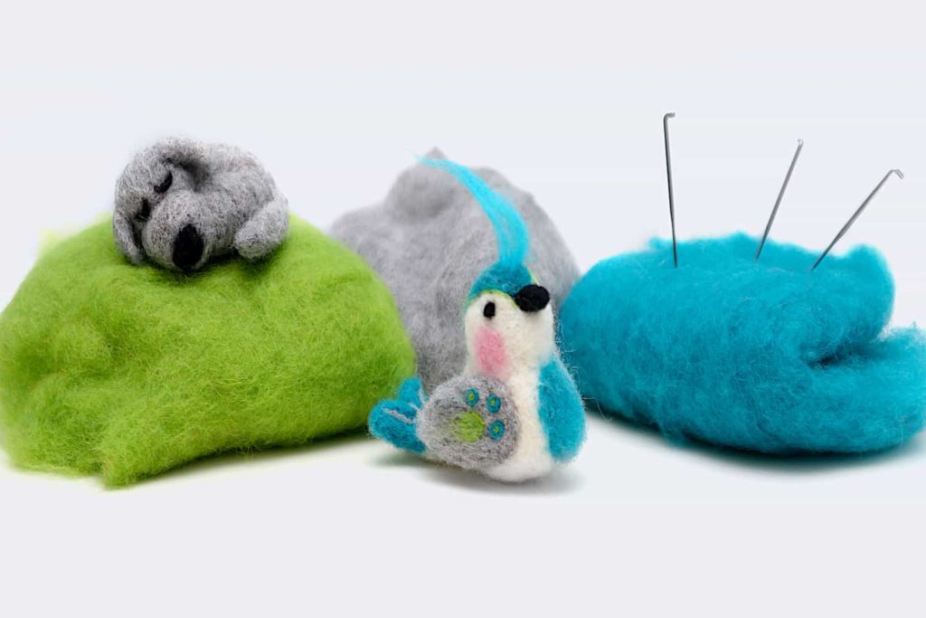 Two small felted animals with posed with felting wool and needles.