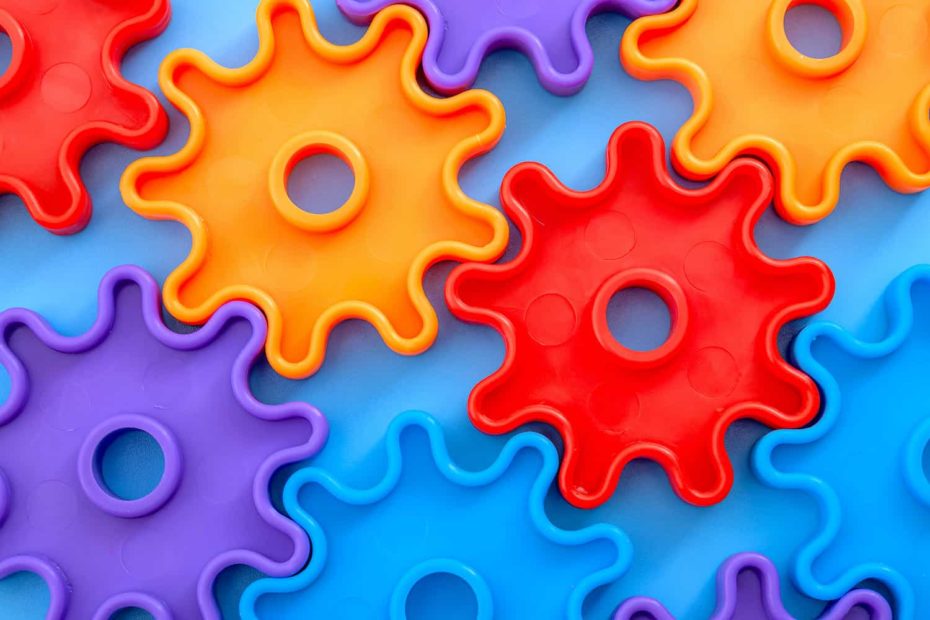 A picture of brightly colored gears on a teal background.
