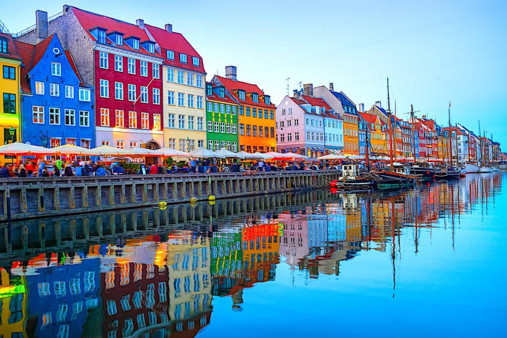 A photo of colorful buildings at the edge of a body of water.