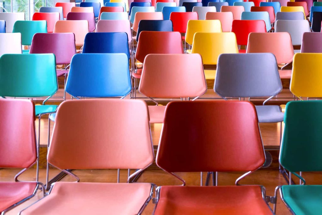 A photo of colorful but empty chairs in an auditorium.