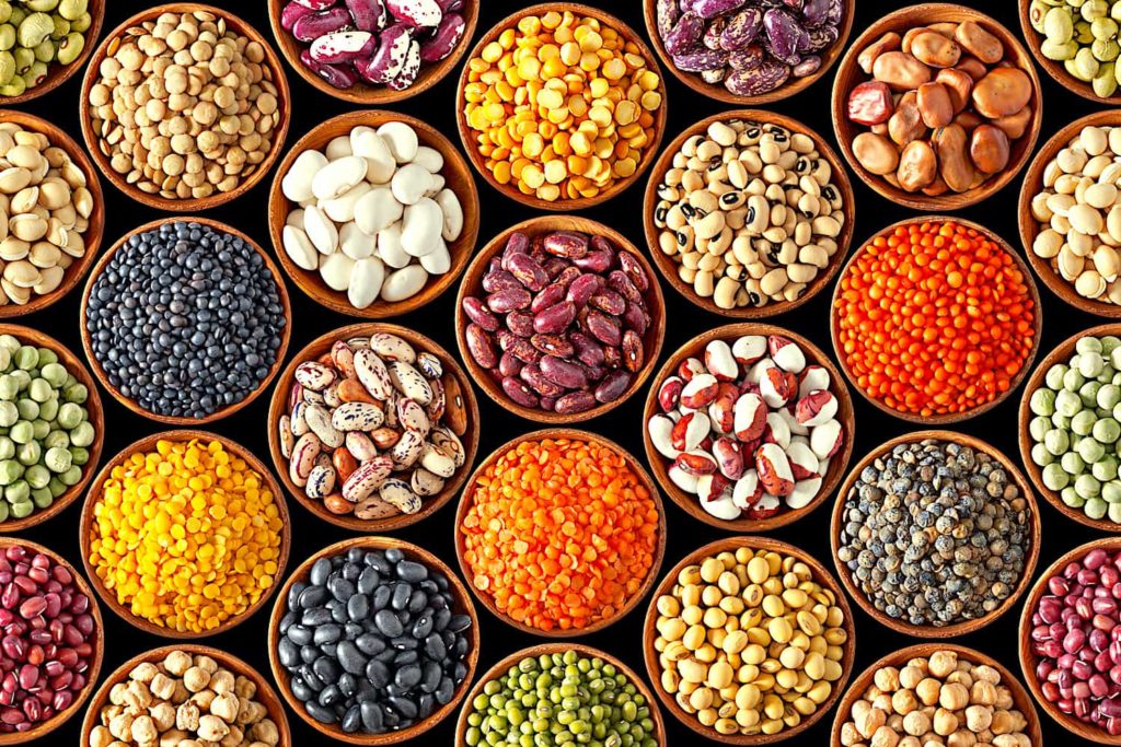 Rows of round bowls containing a colorful assortment of beans.