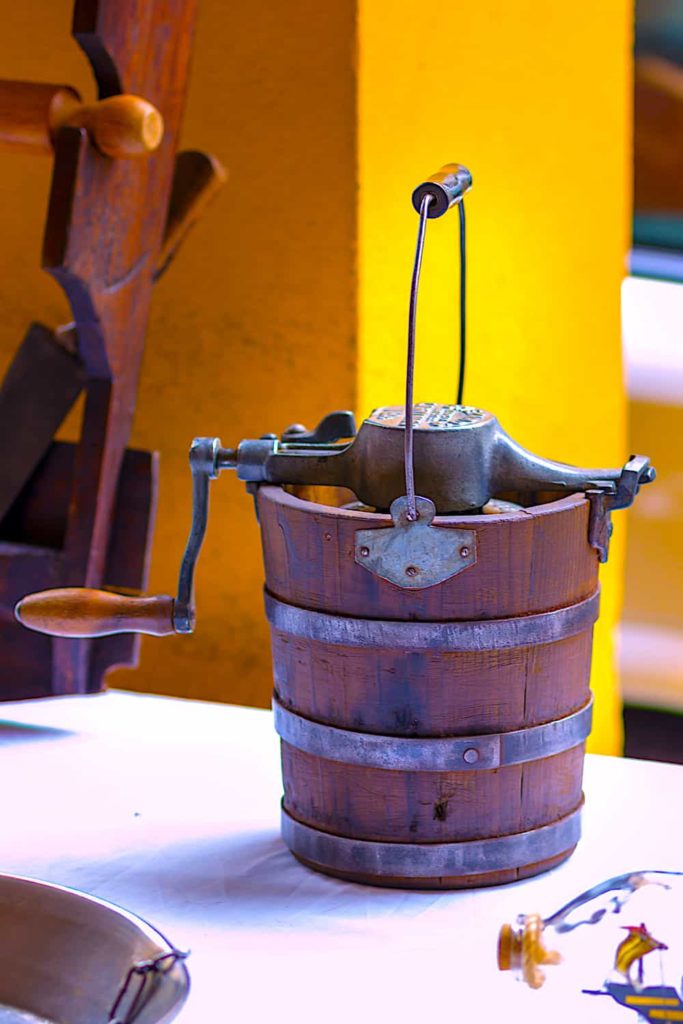 A photograph of an antique hand-cranked ice cream churner.